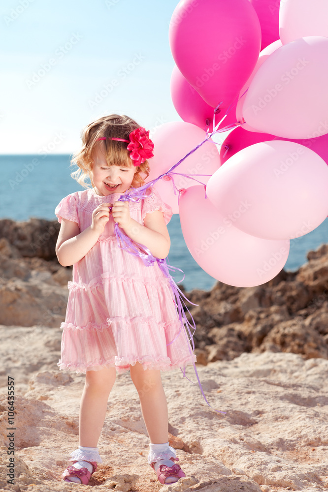 Fototapeta premium Kid girl 4-5 year old celebrating birthday. Holding balloons. Childhood. 