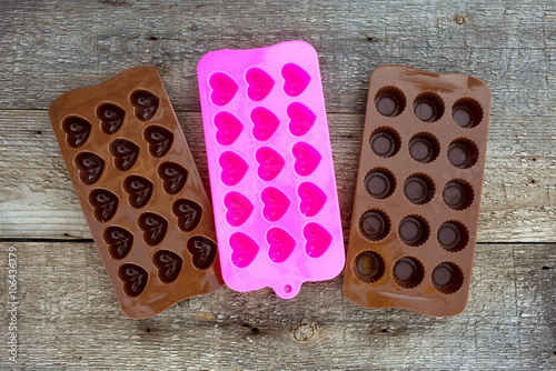 Silicone chocolate mold on wooden background.