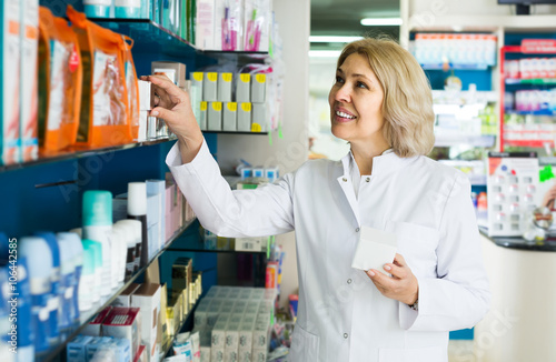 female pharmacist posing in drugstore
