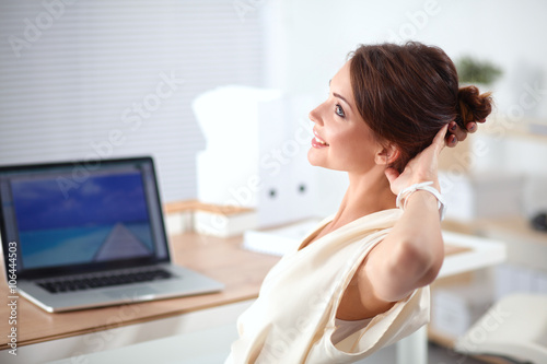 Business woman  relaxing with  hands behind her head and sitting on an office chair