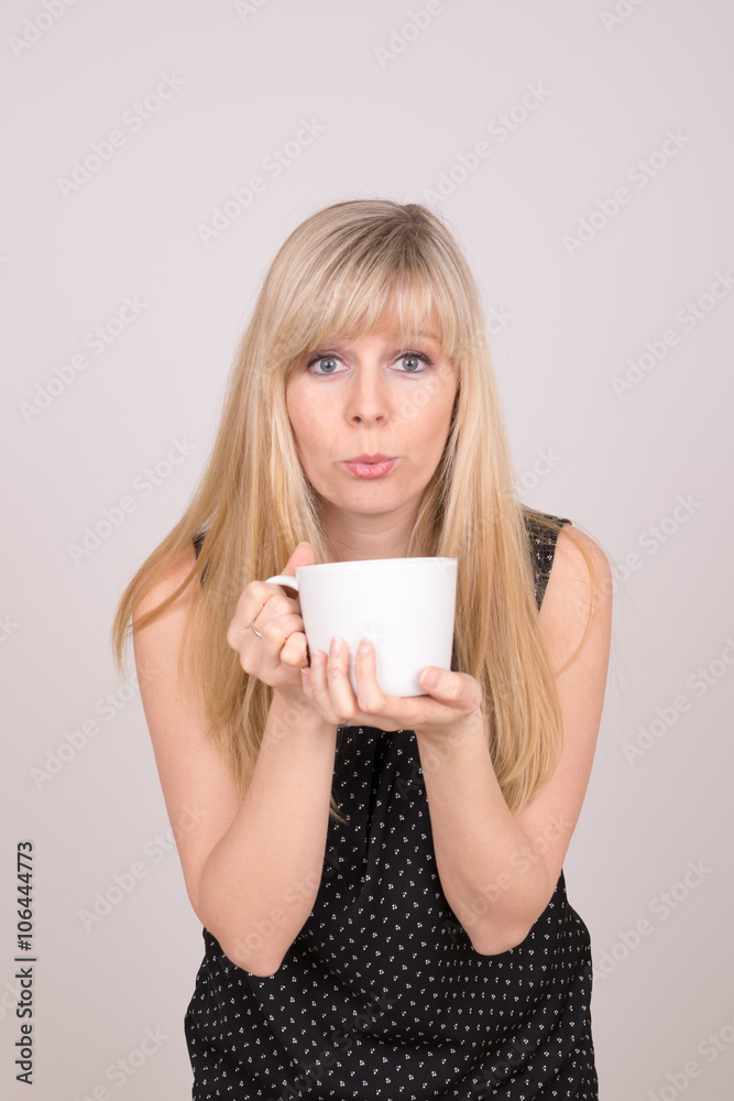 Mädchen pustet in Tasse Mädchen pustet in Tasse