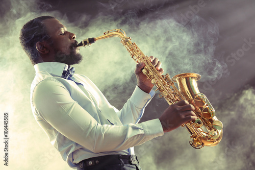Canvas Print African American jazz musician playing the saxophone against smoky background