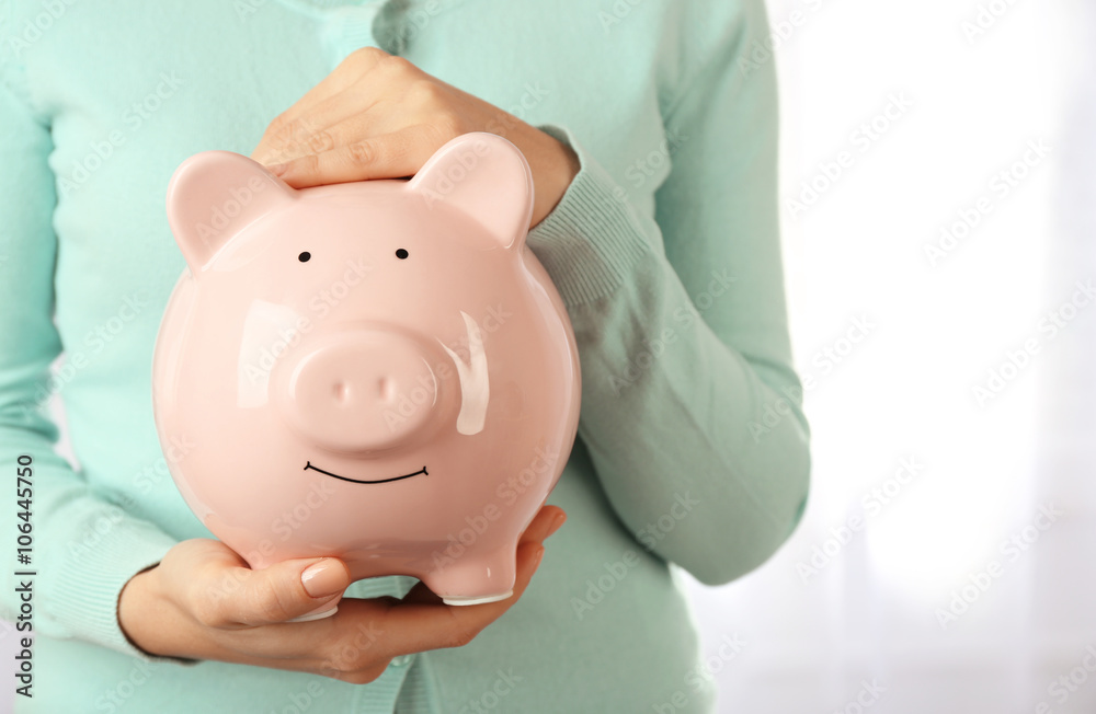 Woman holding piggy bank in hand. Financial savings concept Woman holding piggy bank in hand. Financial savings concept