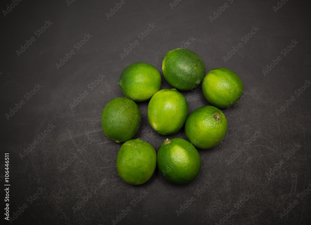 Great amazing closeup view of fresh appetizing green limes on dark grey background