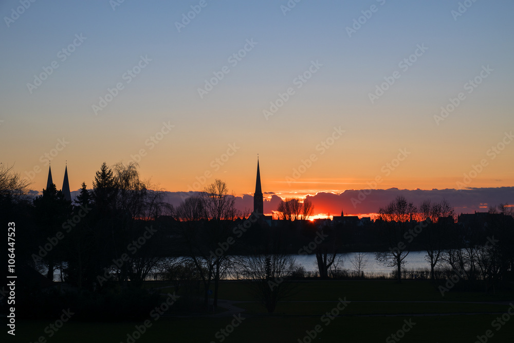 sunset behind the church towers of Luebeck, northern Germany,