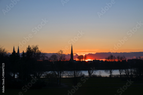 sunset behind the church towers of Luebeck, northern Germany,