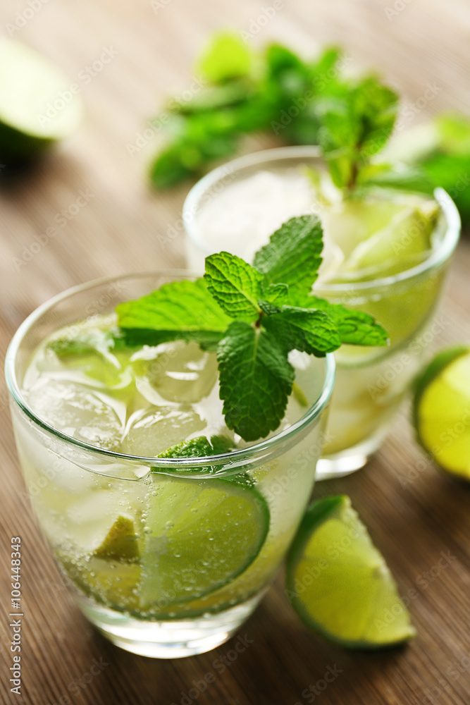 Mojito drink with lime and mint on wooden table Mojito drink with lime and mint on wooden table