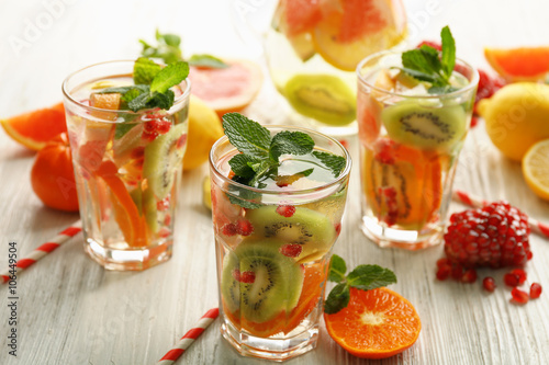 Refreshing cocktails with ice, mint, pomegranate seeds and slices of fruits