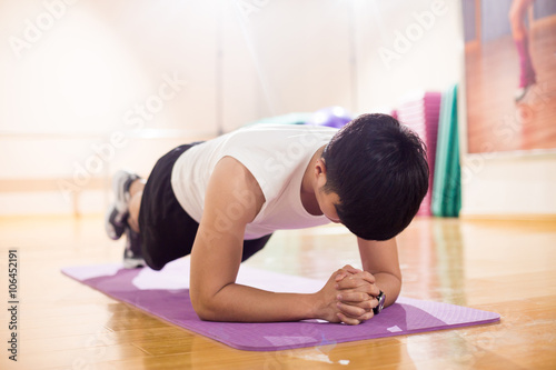 young handsome asian man works out in modern gym