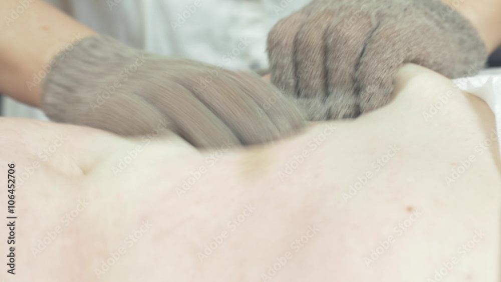 Masseuse make massage of fat stomach to woman in beauty saloon by massage gloves. Tingling. Close up Masseuse make massage of fat stomach to woman in beauty saloon by massage gloves. Tingling. Close up