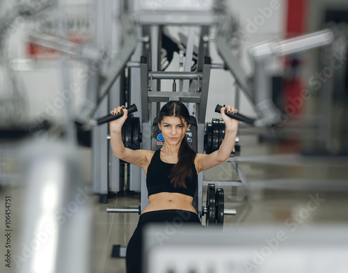 Girl performs exercises on the simulator