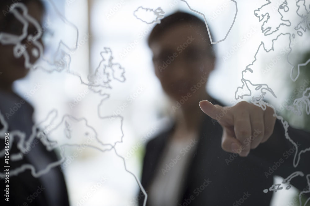 Women are talking while pointing a world map Women are talking while pointing a world map
