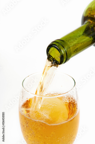Pouring white wine from bottle into the wineglass