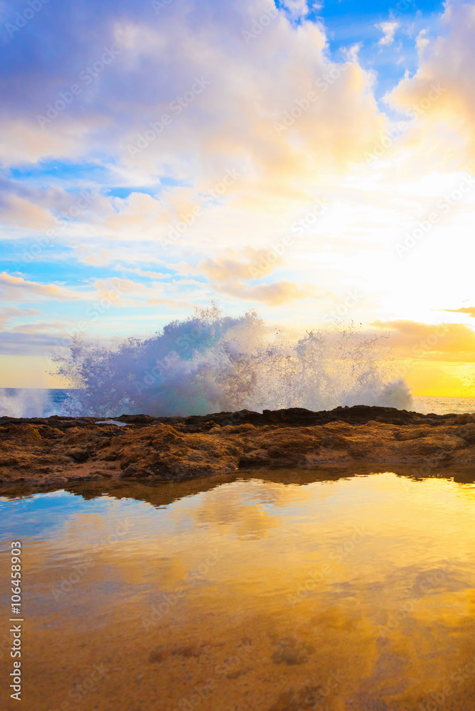 Stock Photo:
Waves crashing on rocky shoreline during sunset golden hour