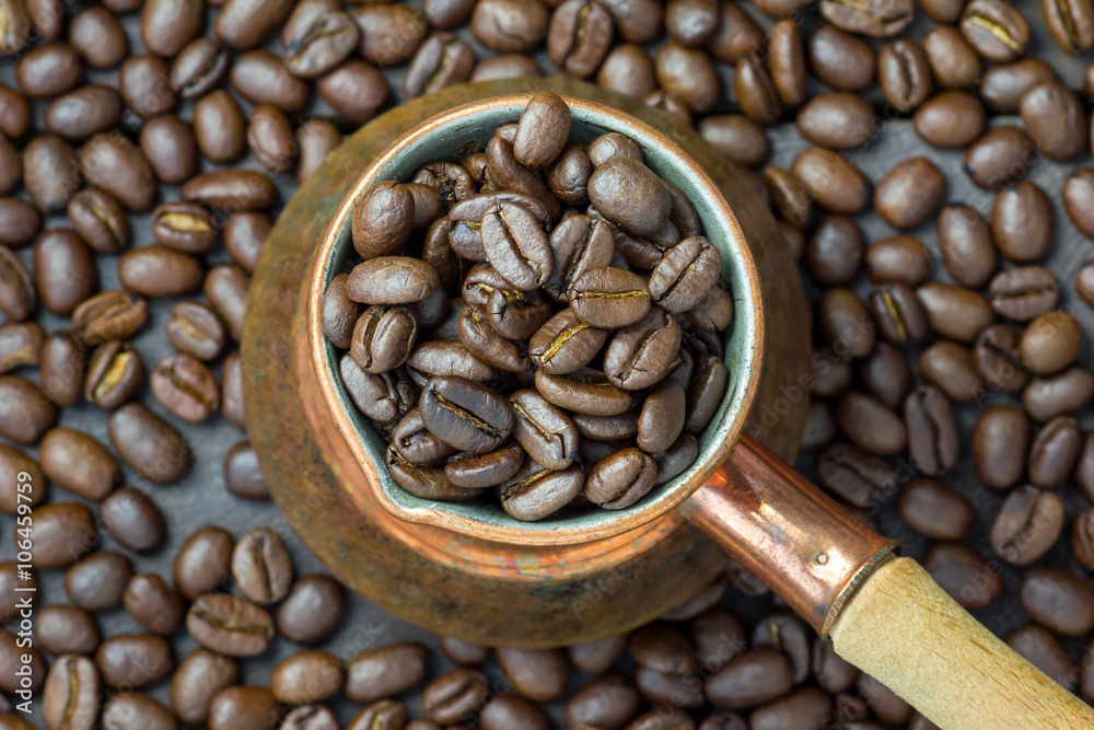 Fototapeta premium Fragrant coffee beans in copper cezve, top view, close up