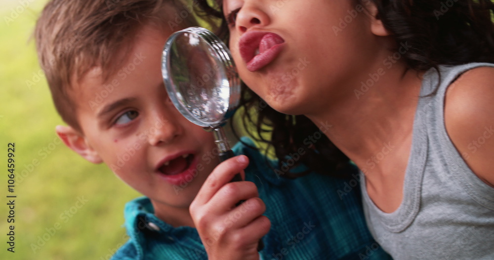 Boy in a park holding a magnifying glass to his eye Boy in a park holding a magnifying glass to his eye