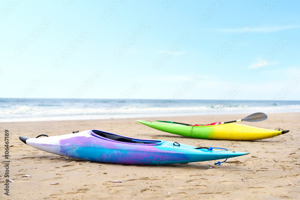Two multicolored canoes on the beach. Selective focus of canoe boats and view to the turquoise sea and blue sky. Two multicolored canoes on the beach. Selective focus of canoe boats and view to the turquoise sea and blue sky.