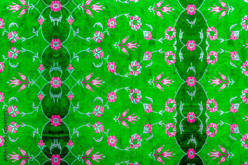  green pattern with leaves and pale red and pink floral features on carpet 