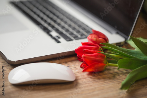 Fototapeta Naklejka Na Ścianę i Meble -  Desk with a computer and bouquet of tulips