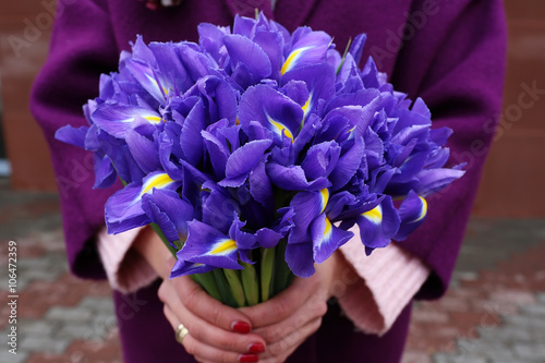 Bouquet of irises in the girl s hands