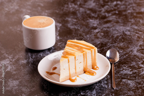 Slice of cheesecake with caramel sauce  cup of coffee