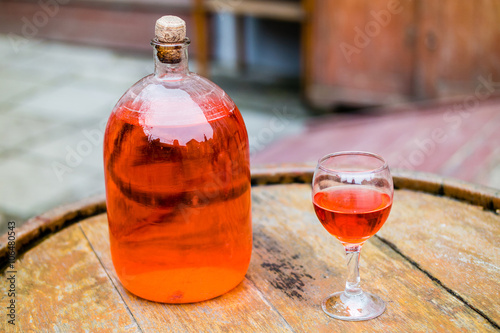 Wine in old bottle on a barrel. photo