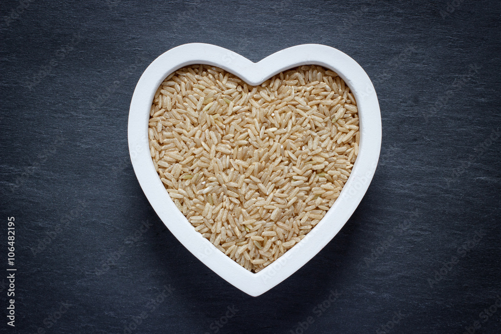 Heart shaped bowl filled with brown rice Heart shaped bowl filled with brown rice