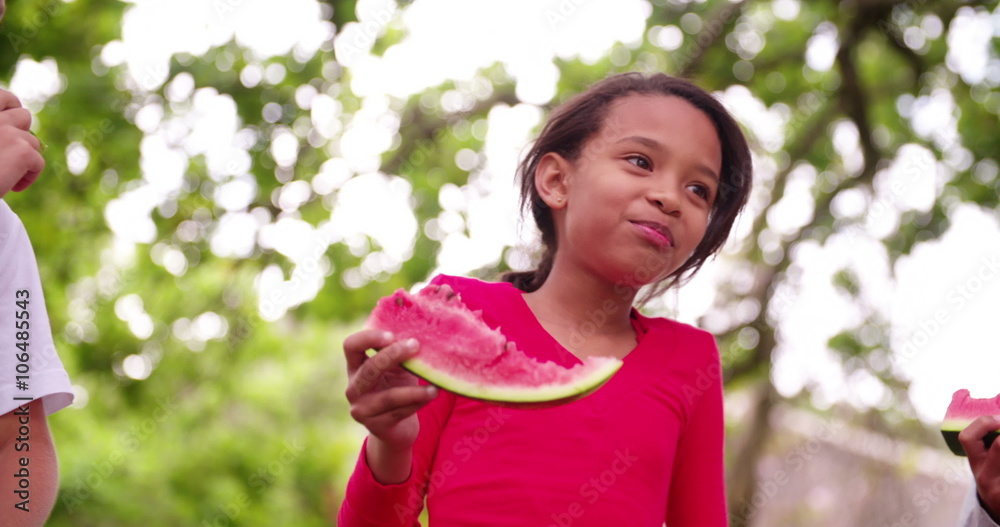Mixed race group of children eating watermelon smiling at camera Mixed race group of children eating watermelon smiling at camera