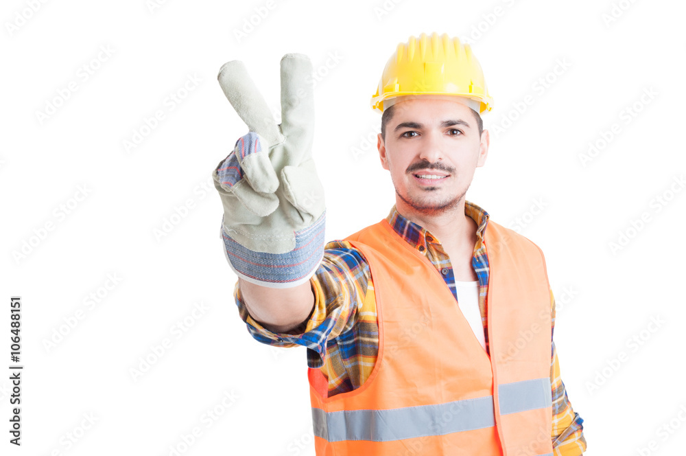 Handsome smiling constructor doing peace or victory gesture
