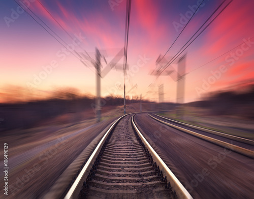 Railway station on the background of blue sky at colorful sunset with motion blur effect. Railroad in Ukraine. 