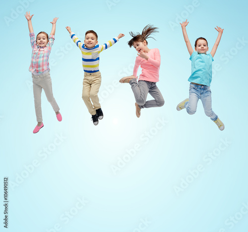 happy little children jumping in air over blue