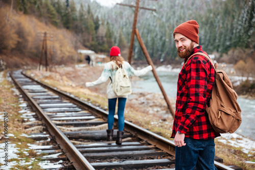 Man and woman walking on old railroad in mountains