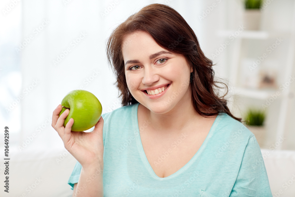 happy plus size woman eating green apple at home happy plus size woman eating green apple at home
