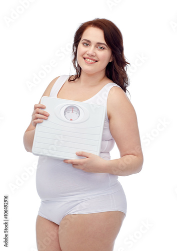 happy young plus size woman holding scales