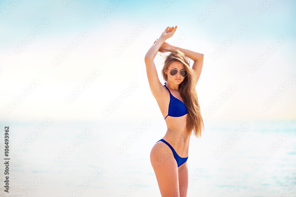 Portrait of woman in black swim posing on tropical beach