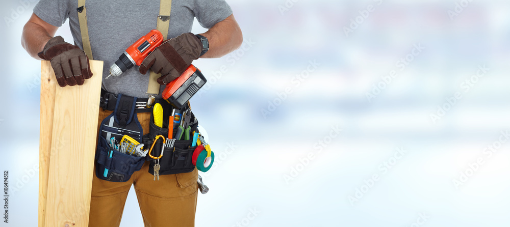 Builder handyman with drill and wooden plank.