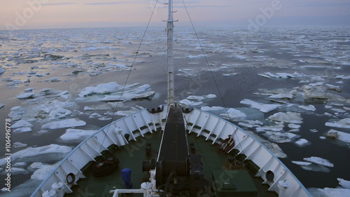 Research vessel in icy arctic sea on a sunny day