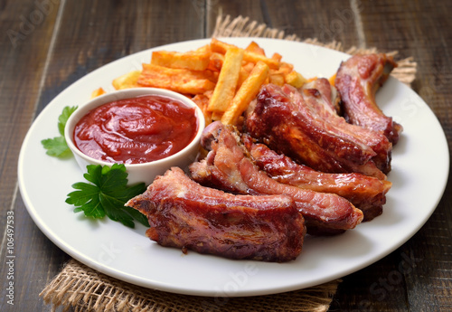 Pork ribs and tomato sauce on white plate
