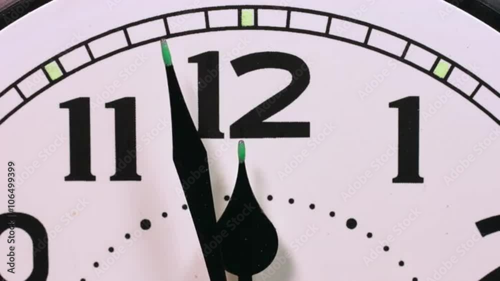 Close up time lapse of clock hands reaching 12 o'clock midnight, pausing and then going backwards. Turning the clock back. Going back in time. Returning to the previous day.