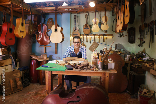 Portrait Of Happy Artisan Lute Maker In Guitar Shop Smiling