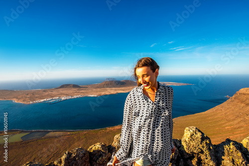 Female tourist standing on El Rio viewpoint on Lanzarote island with Graciosa island on the background in Spain photo