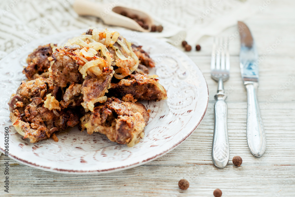 Fried chicken liver with onions and spices on a wooden background
Fried chicken liver with onions and spices on a wooden background