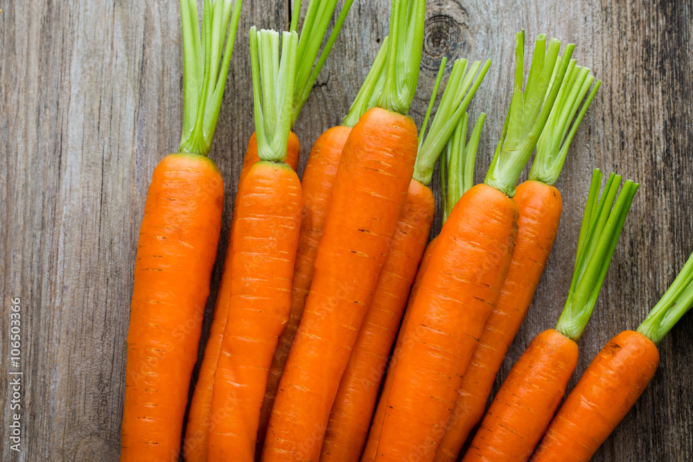 Fresh carrots bunch on rustic wooden background. Fresh carrots bunch on rustic wooden background.
