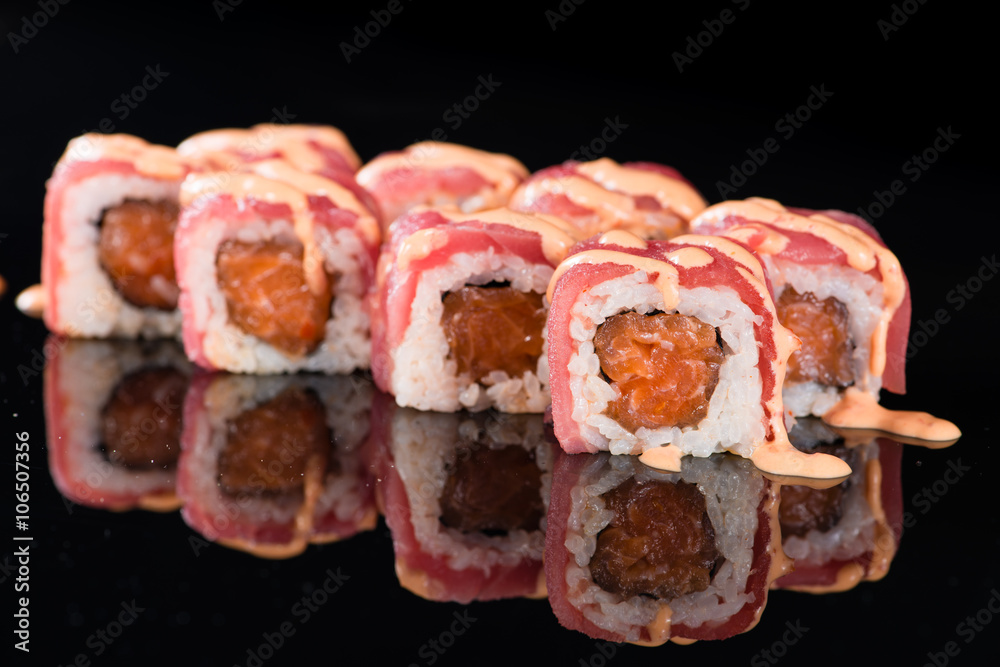 Sushi Roll with salmon over black background with reflection Sushi Roll with salmon over black background with reflection
