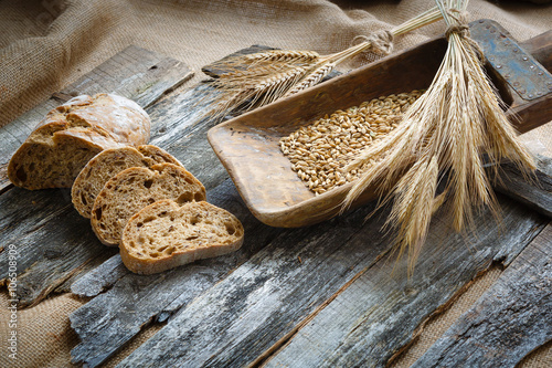 Fresh bread and wheat on the wooden boards