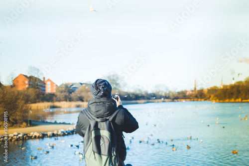 young tourist man taking photos of landscape near Christiania , photo