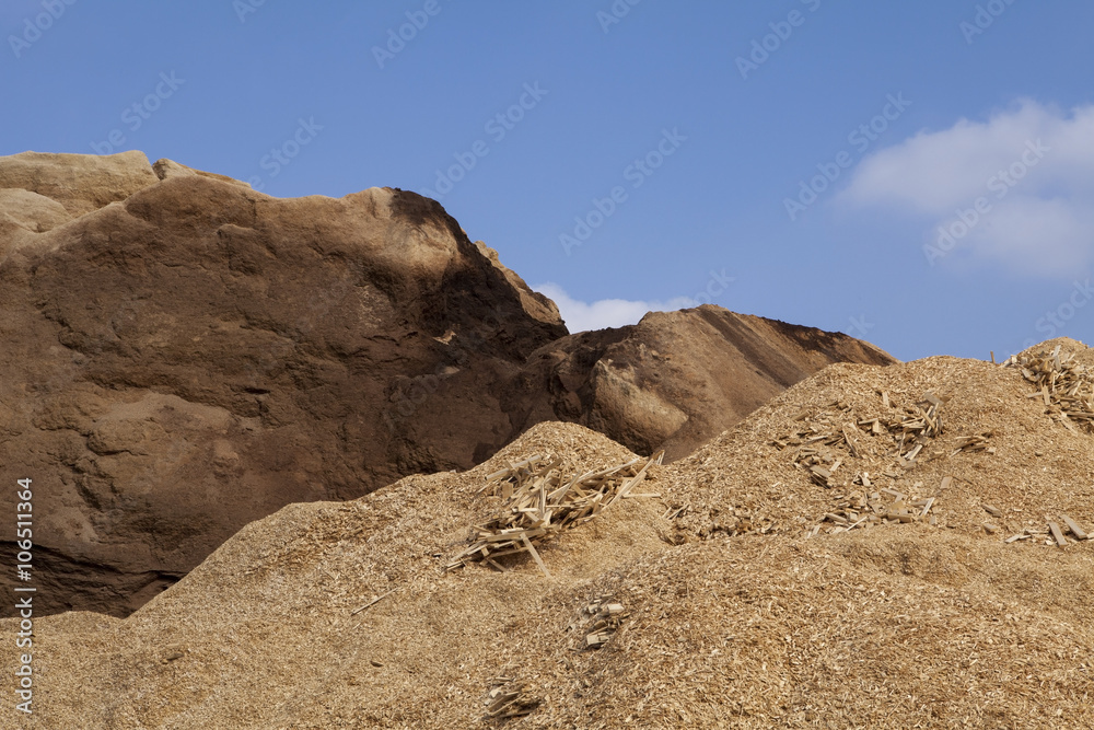 Pile of wood chips and sawdust used for biofuel manufacturing. Wood chips is a renewable and sustainable energy source for heating. 