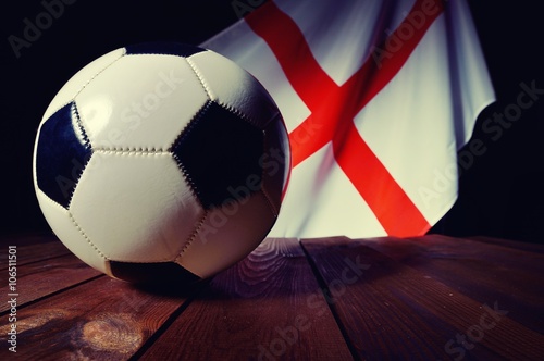 Flag of England with football on wooden boards as the background
