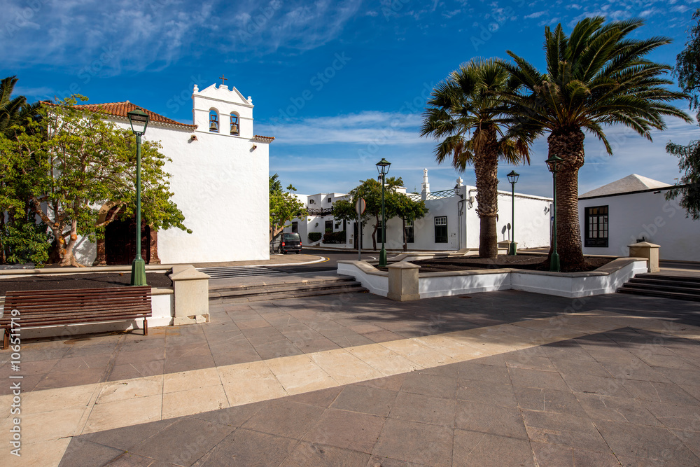 Central square with church and traditional whitewashed buildings in Yaiza village on Lanzarote island in Spain