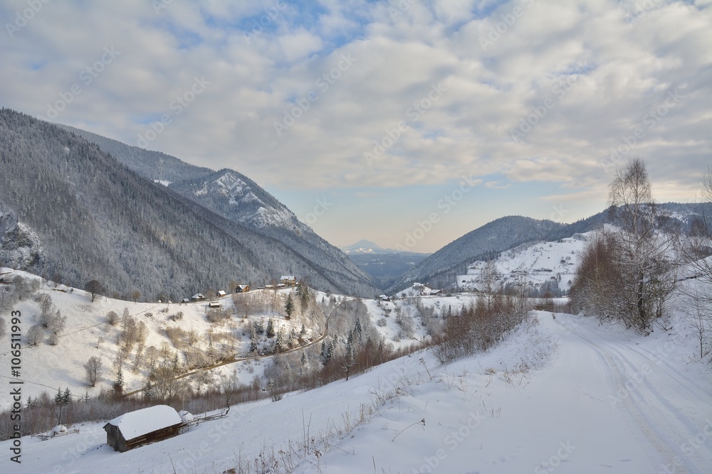 Wintry rural mountain scenery in the valleys of Bucegi mountains in Magura village, Brasov county, Romania. Touristic destinations for winter vacation. Wintry rural mountain scenery in the valleys of Bucegi mountains in Magura village, Brasov county, Romania. Touristic destinations for winter vacation.